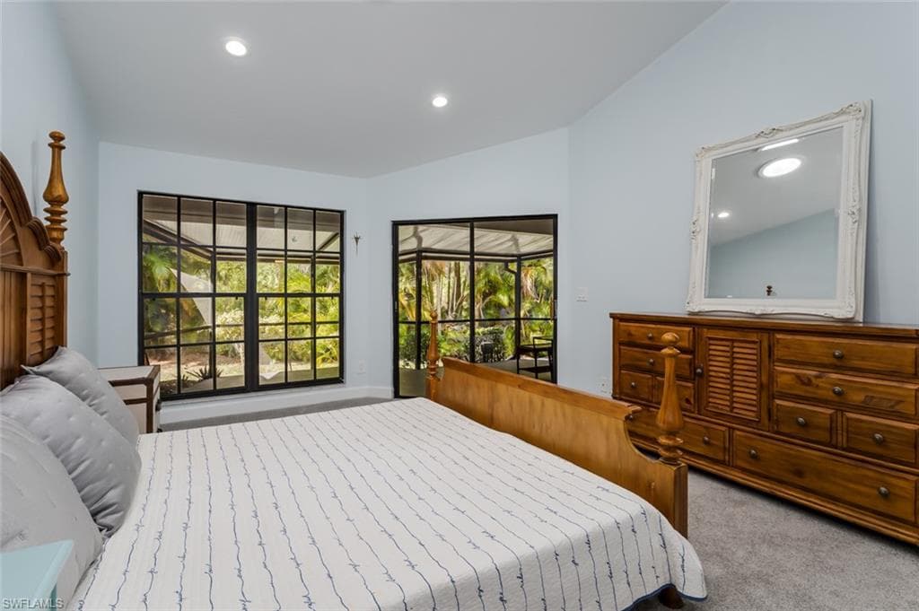 Bedroom with light carpet, vaulted ceiling, and recessed lighting