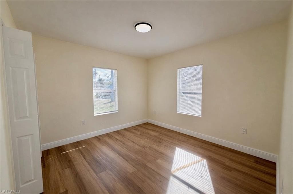Unfurnished room with healthy amount of natural light and wood finished floors