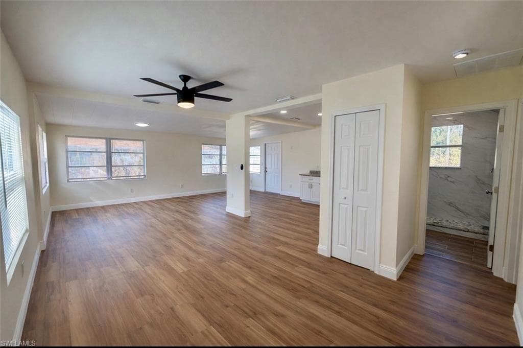 Unfurnished living room with dark wood-style floors, a ceiling fan, and recessed lighting