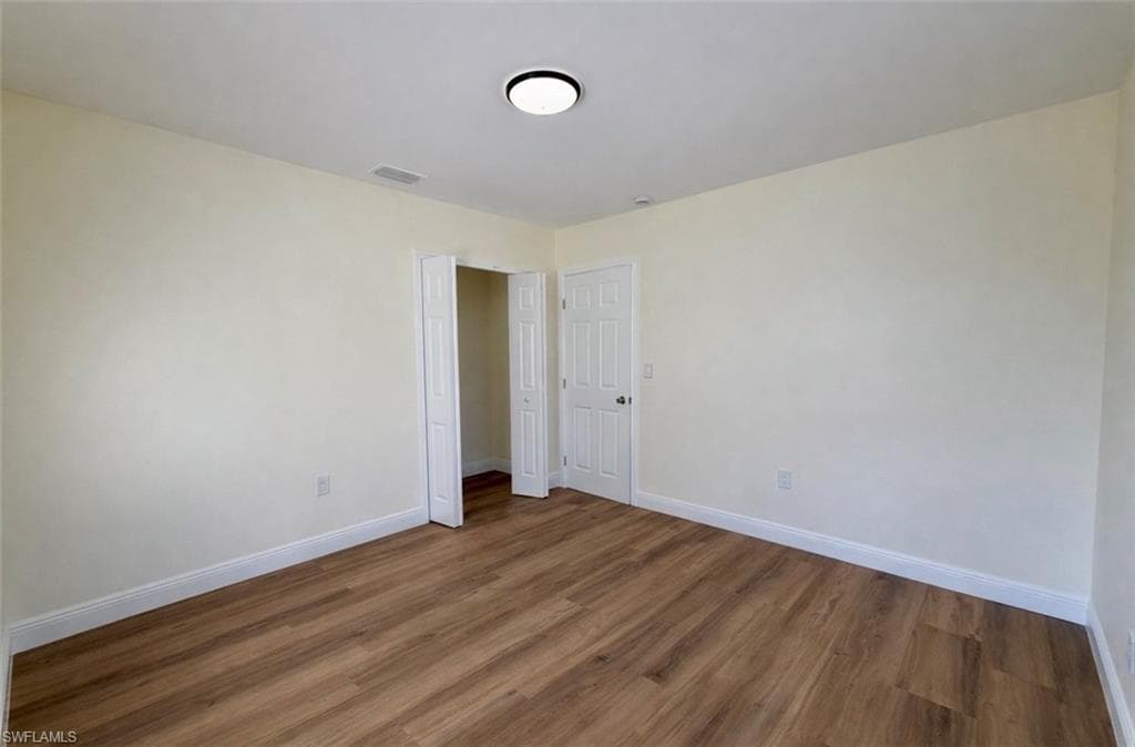Unfurnished room featuring wood finished floors and baseboards