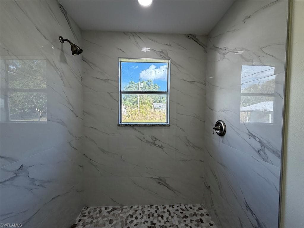 Bathroom with a marble finish shower