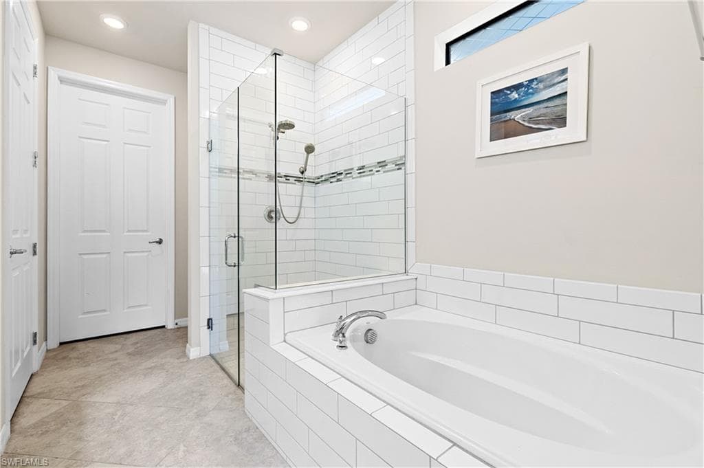 Bathroom featuring a garden tub, a shower stall, recessed lighting, and light tile patterned floors