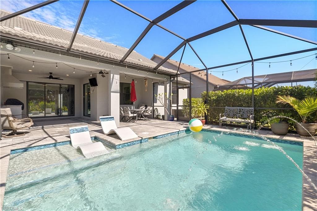 Outdoor pool with a lanai, a sunroom, a patio area, and outdoor dining space