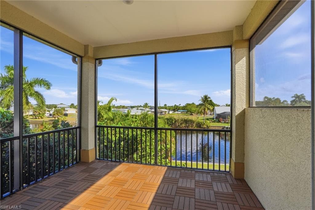 Unfurnished sunroom featuring a water view and a textured wall