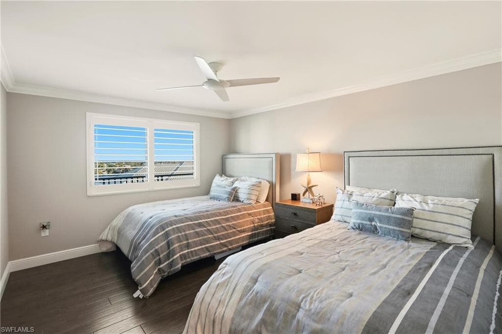 Bedroom featuring crown molding, dark wood finished floors, and ceiling fan