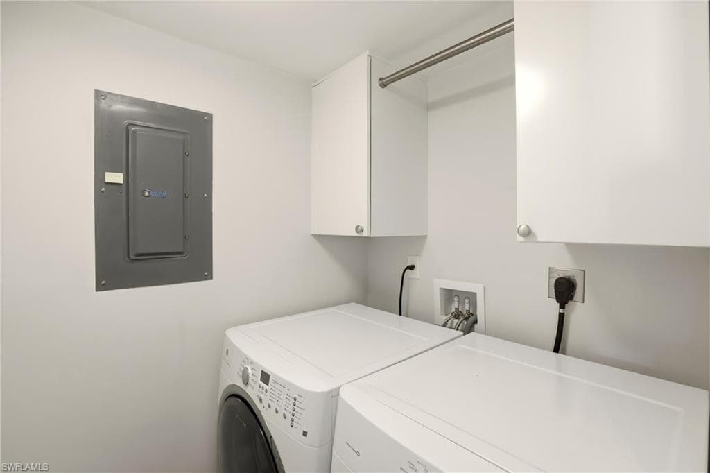 Laundry room with electric panel, cabinet space, and independent washer and dryer