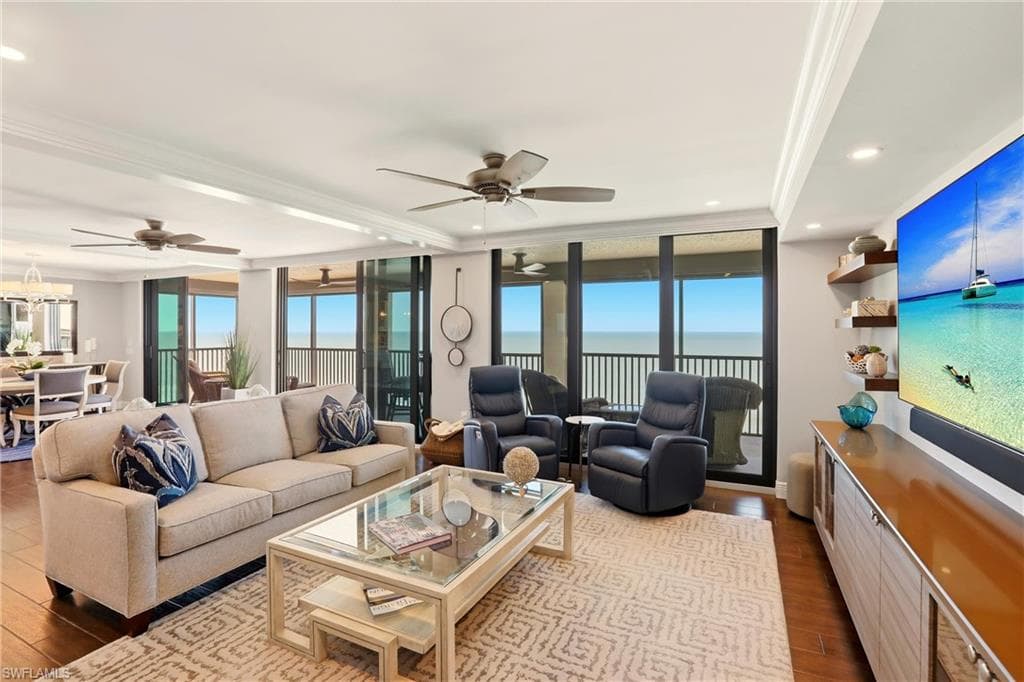 Living area featuring plenty of natural light, crown molding, dark wood finished floors, expansive windows, and recessed lighting