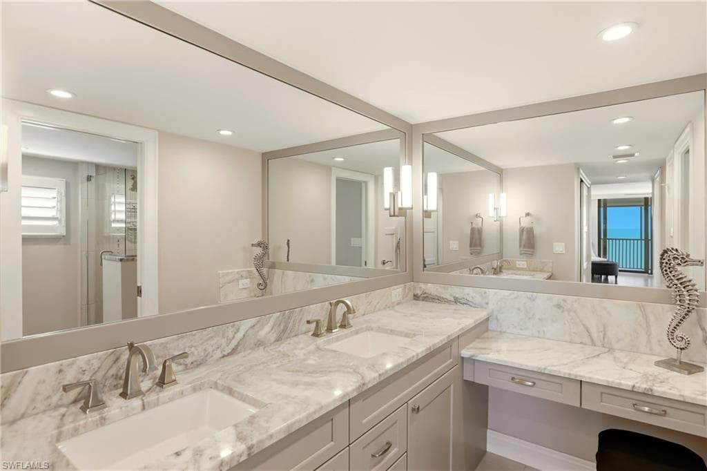 Full bathroom featuring double vanity, recessed lighting, and a shower stall