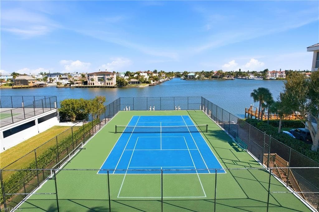View of tennis court featuring a water view