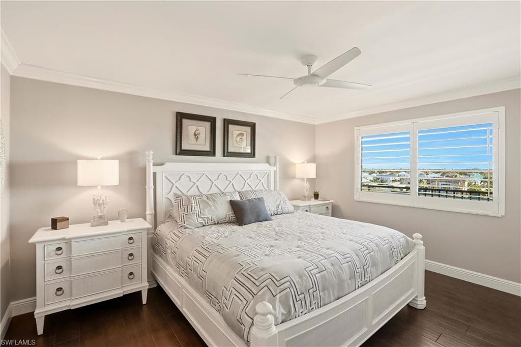 Bedroom with ornamental molding, ceiling fan, and dark wood-style flooring