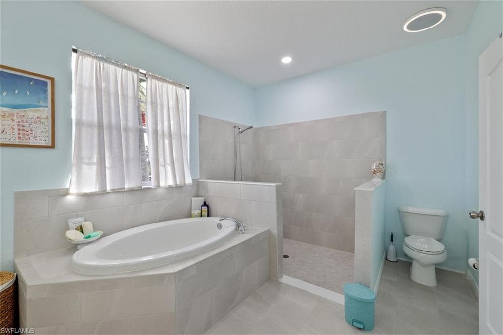 Full bath with a bath, a walk in shower, and tile patterned flooring