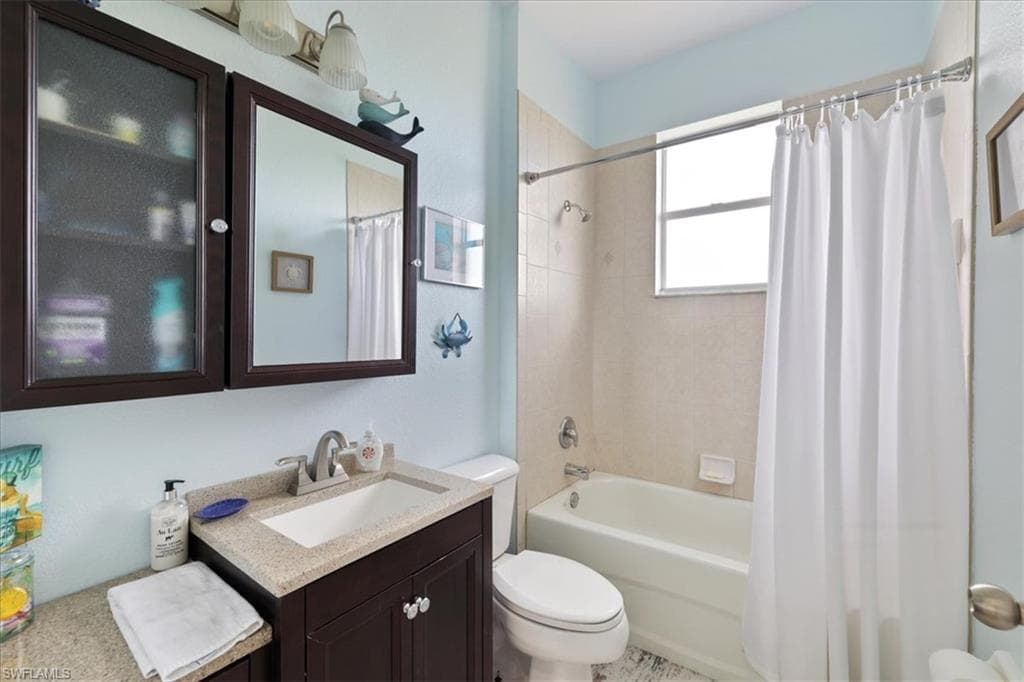 Bathroom with vanity and shower / bath combination with curtain