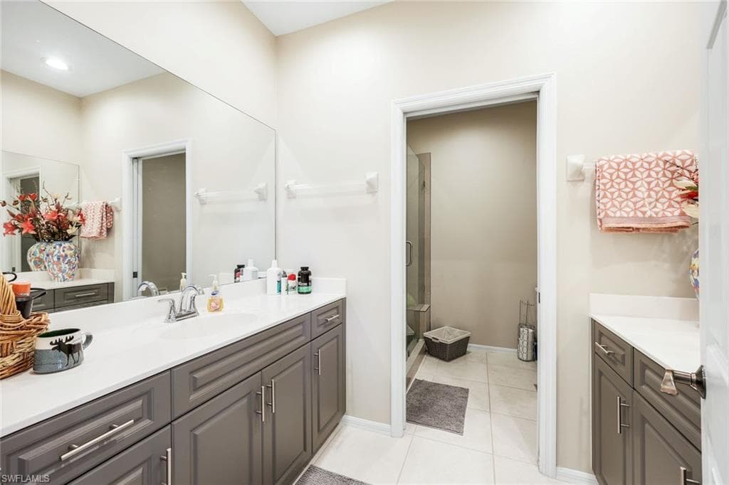 Bathroom featuring vanity, a shower stall, and light tile patterned floors