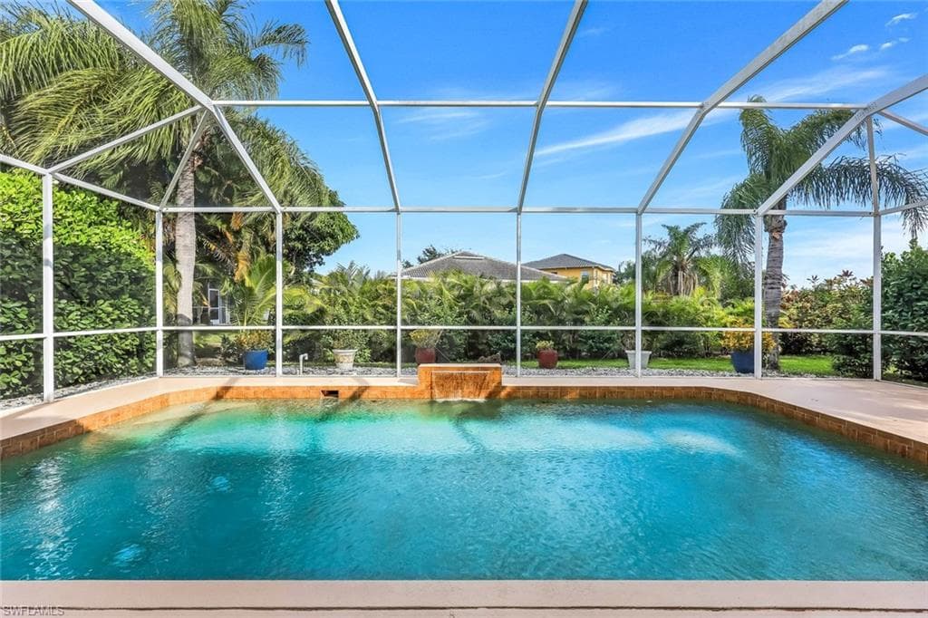 Outdoor pool featuring a sunroom and glass enclosure
