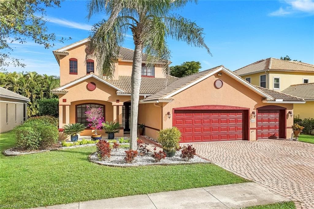 Mediterranean / spanish house with stucco siding, decorative driveway, a garage, and a front yard
