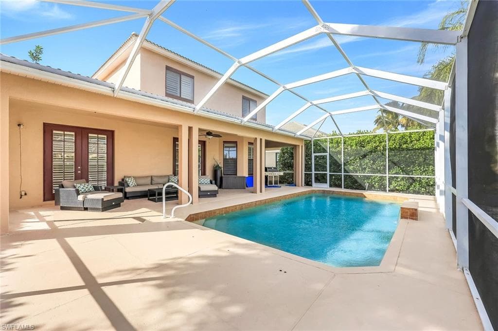 Swimming pool with a sunroom, an outdoor hangout area, a patio, glass enclosure, and french doors