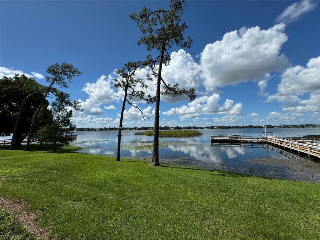 Dock with a lawn and a water view