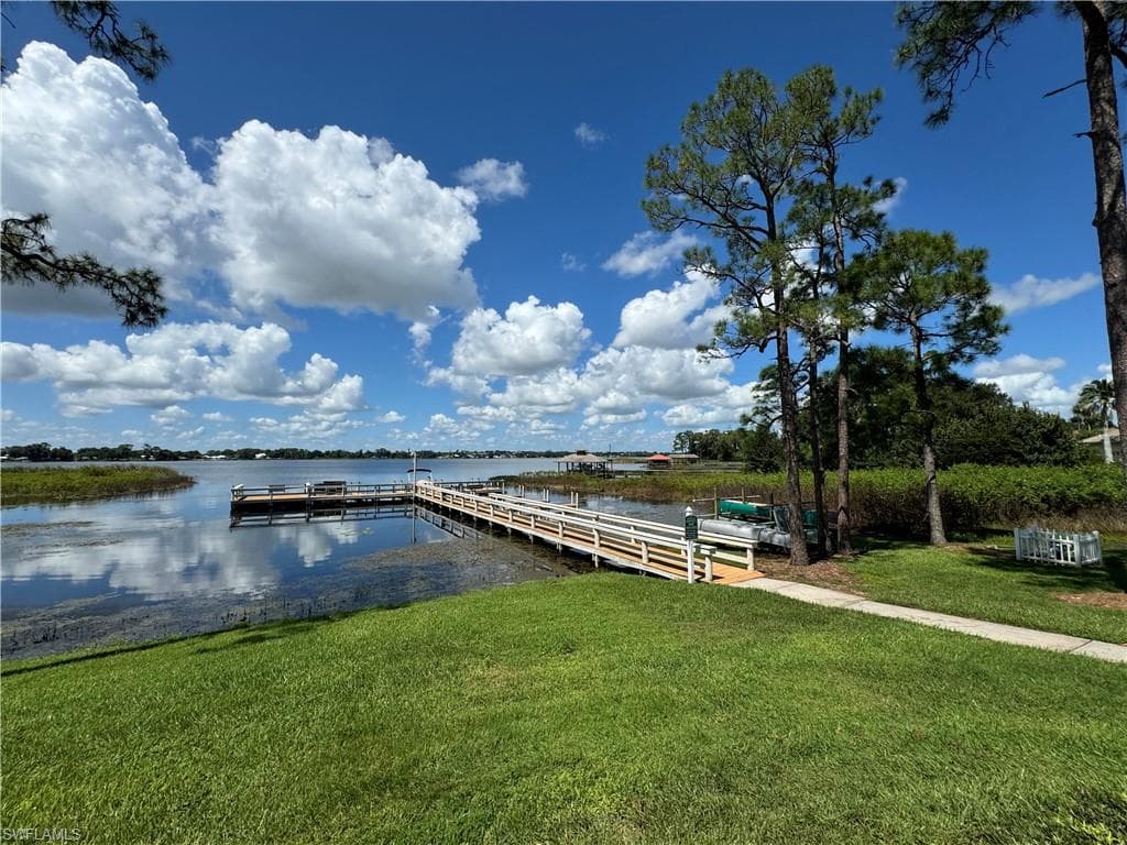 Dock area with a lawn and a water view