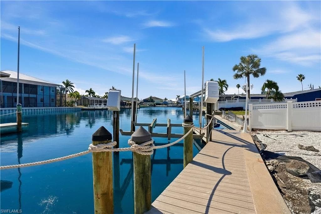 Private dock featuring a boat lift, sturdy pilings, and a rope railing - Virtually Edited Image