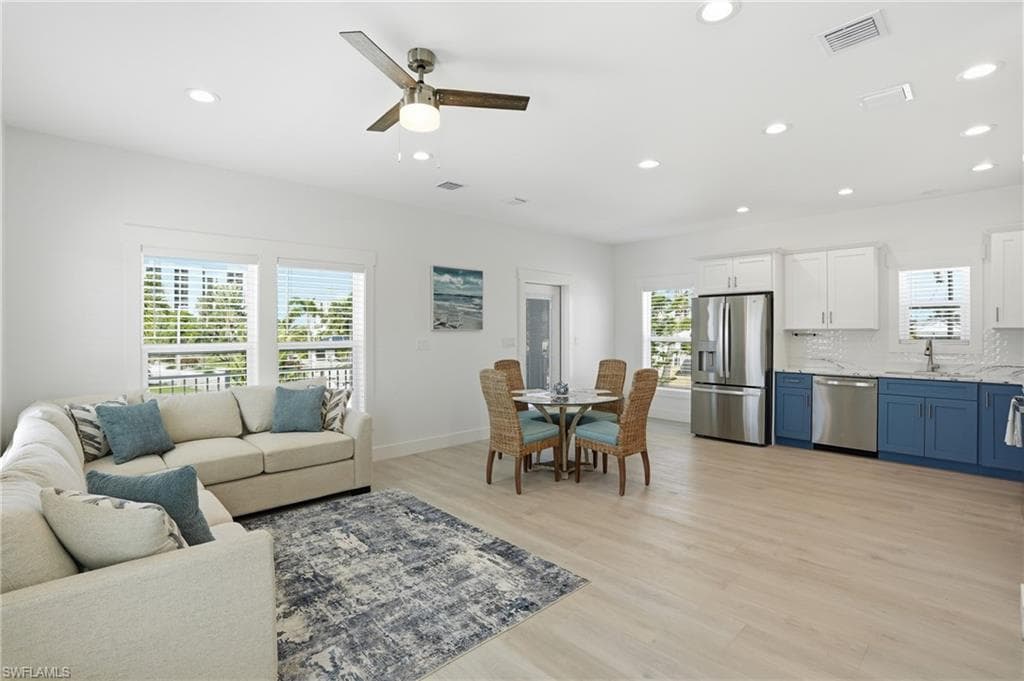 Open-concept living space featuring light wood-finish flooring and recessed lighting - Virtually Edited Image