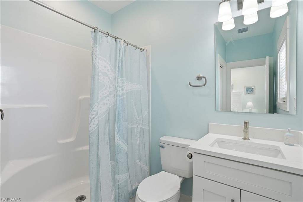 Full bathroom featuring a white vanity with an integrated sink, a sleek mirror, and a shower-tub combination with a white surround - Virtually Edited Image