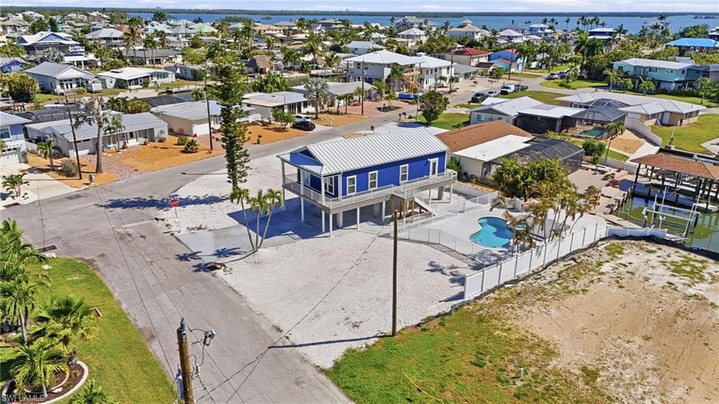 Elevated coastal residence featuring a vibrant blue exterior and metal roof - Virtually Edited Image