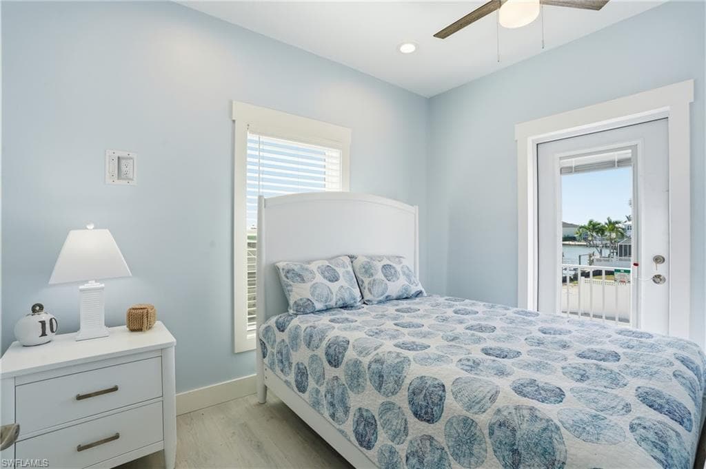 Light blue wall paint and white trim, featuring a ceiling fan, recessed lighting, and wood-finish flooring - Virtually Edited Image