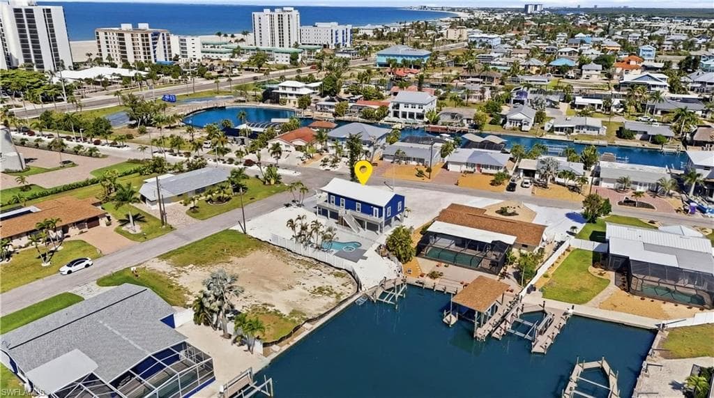 Waterfront property featuring a private boat dock, elevated structure, and a backyard pool - Virtually Edited Image