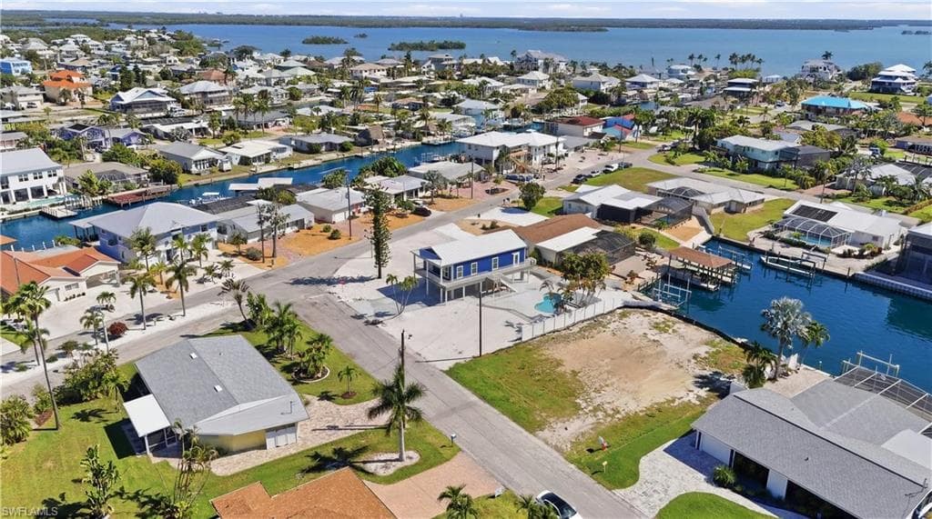 Aerial perspective showcasing a residential area with canal access, featuring numerous properties with private boat docks - Virtually Edited Image