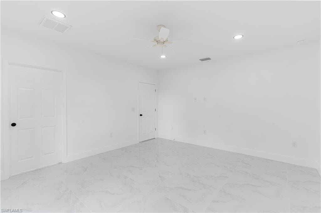Unfurnished room featuring recessed lighting, light marble finish flooring, and ceiling fan