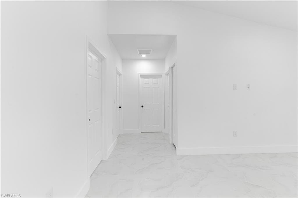 Corridor with baseboards and light marble finish floors