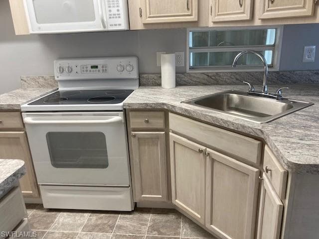 Kitchen featuring white appliances, light brown cabinets, and light countertops