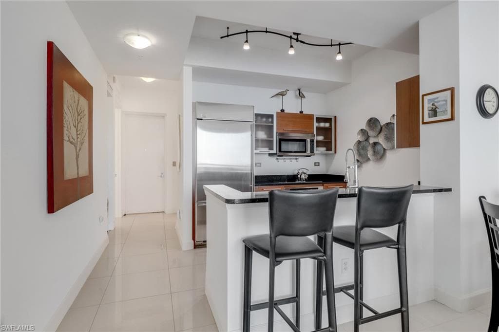 Kitchen with stainless steel appliances and breakfast bar.