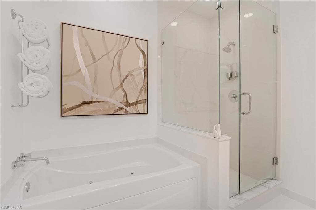 Bathroom with a glassed in shower and jetted tub