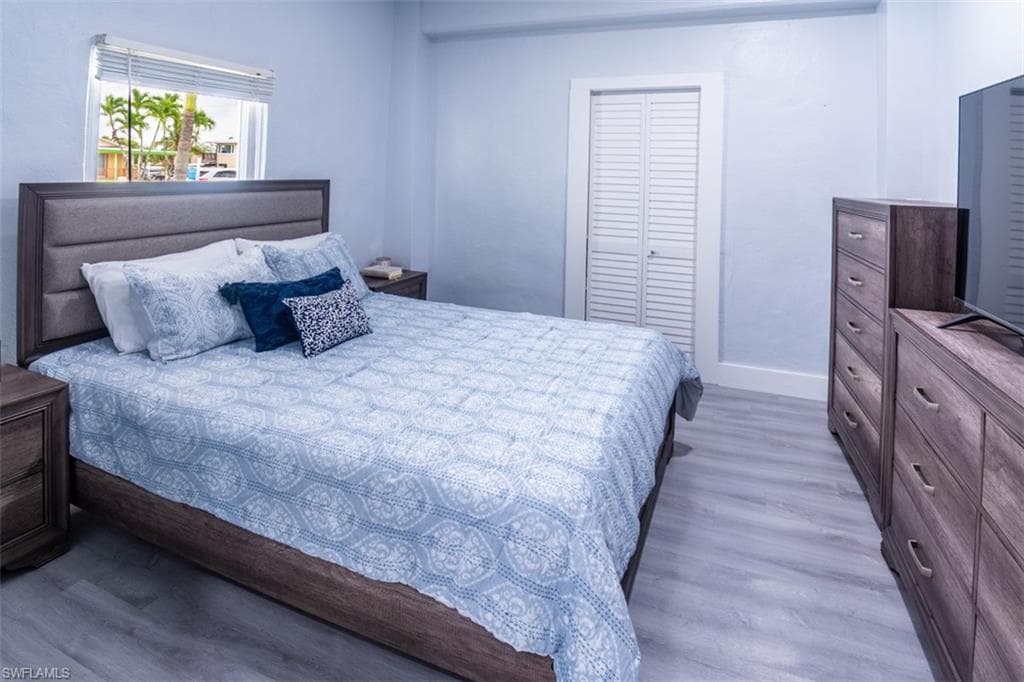 Bedroom with light wood-style flooring and a closet