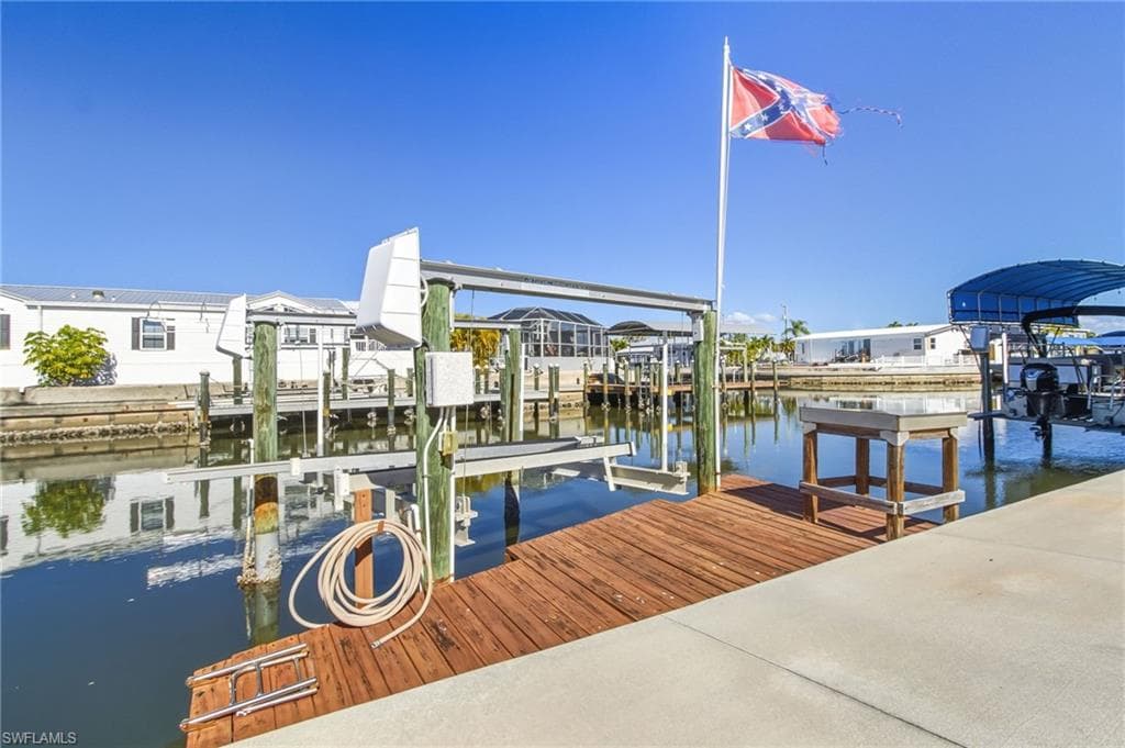 Dock area featuring boat lift and a water view