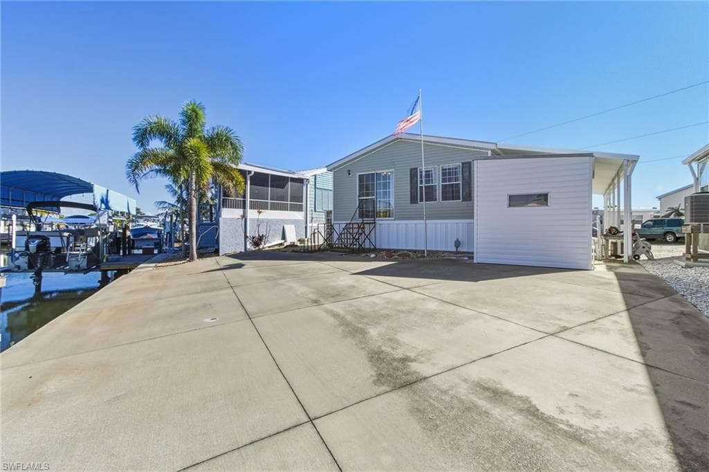 View of front of home with a dock and driveway