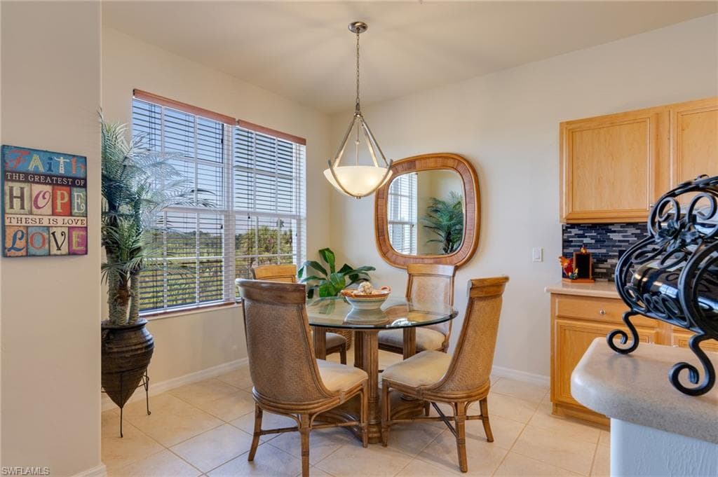 Dining area with light tile patterned floors and baseboards