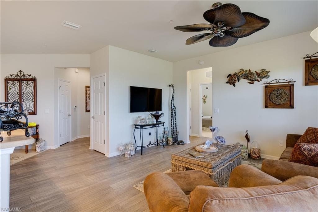 Living area with light wood-type flooring and a ceiling fan