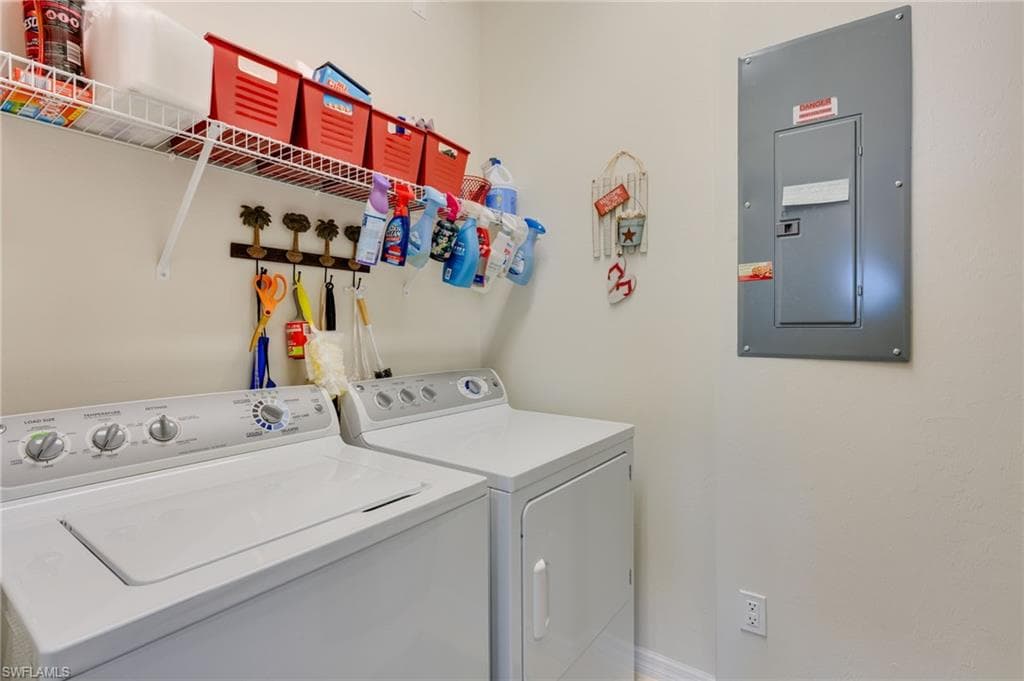 Laundry room featuring electric panel and washer and clothes dryer