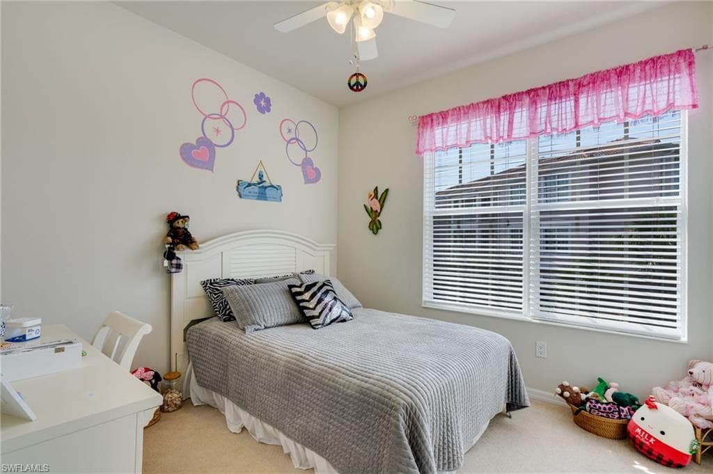 Bedroom with light colored carpet and a ceiling fan