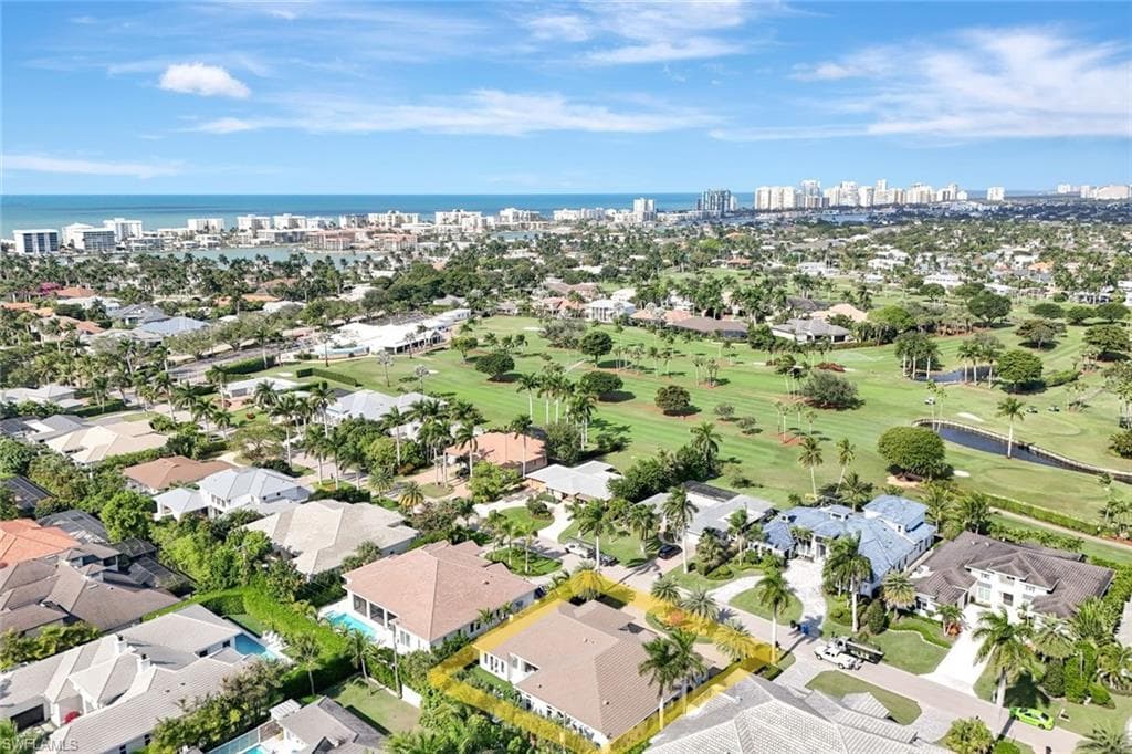 Aerial overview of property's location featuring skyline, a golf course, and nearby suburban area