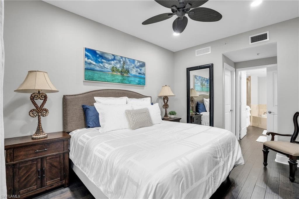 Bedroom with dark wood-type flooring, a ceiling fan, and ensuite bathroom