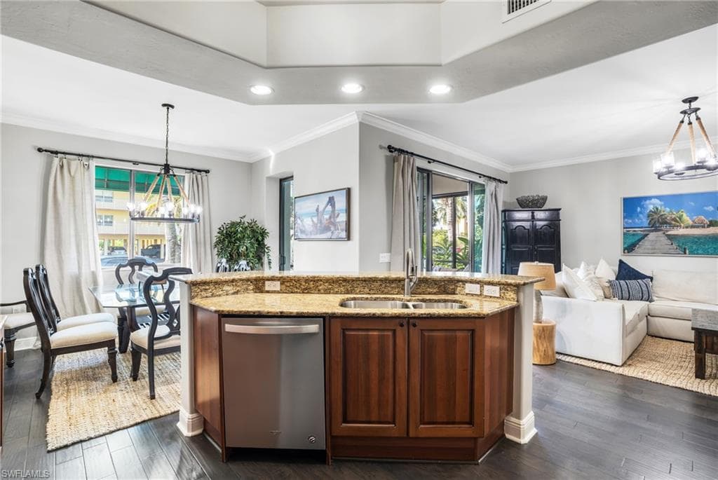 Kitchen with a chandelier, decorative light fixtures, light stone countertops, recessed lighting, and ornamental molding