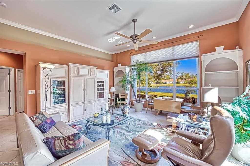 Living area with light tile patterned floors, crown molding, ceiling fan, and recessed lighting