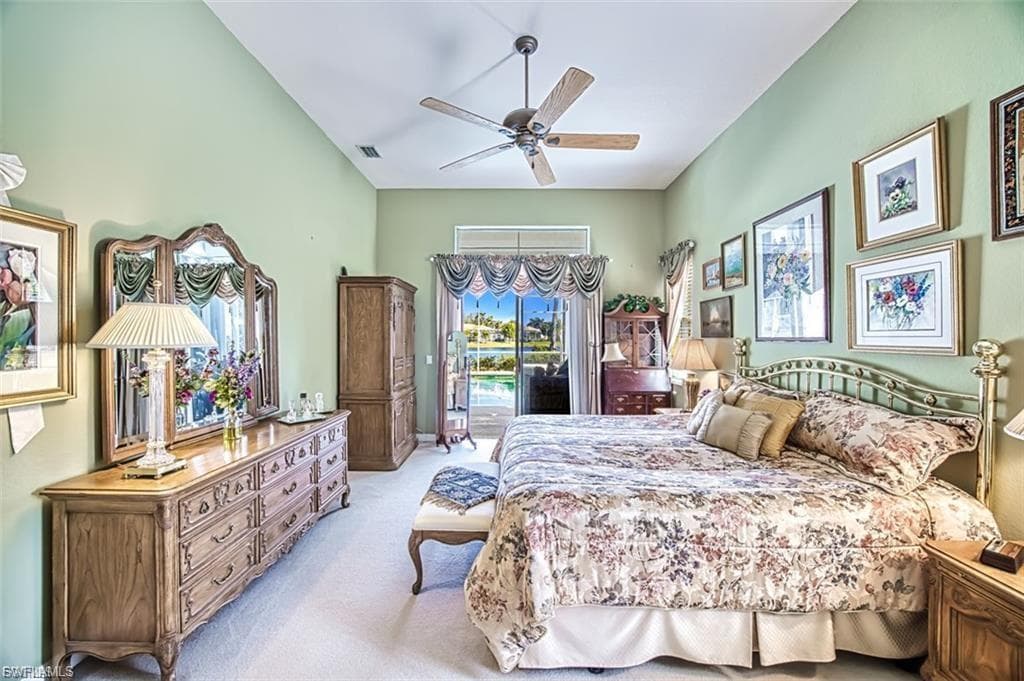 Bedroom featuring access to exterior, light carpet, ceiling fan, and vaulted ceiling