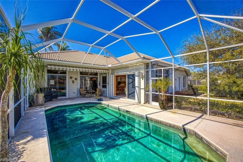 Swimming pool with a sunroom, a lanai, and a patio