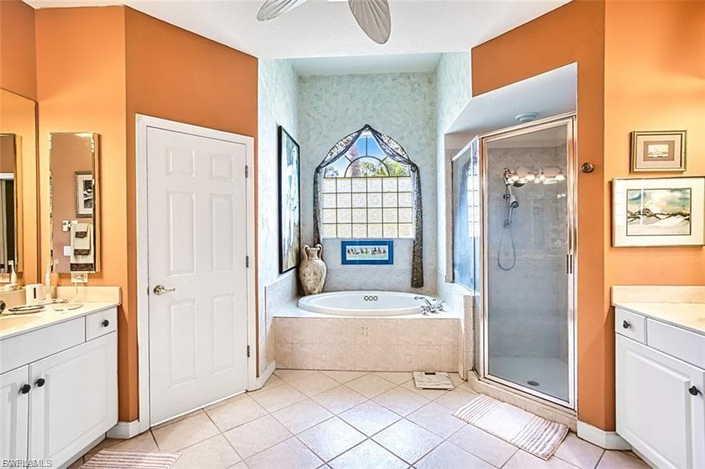 Bathroom with vanity, a shower stall, light tile patterned floors, a garden tub, and ceiling fan