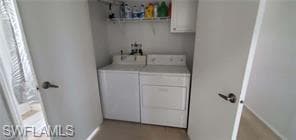 Washroom with washer and clothes dryer and baseboards