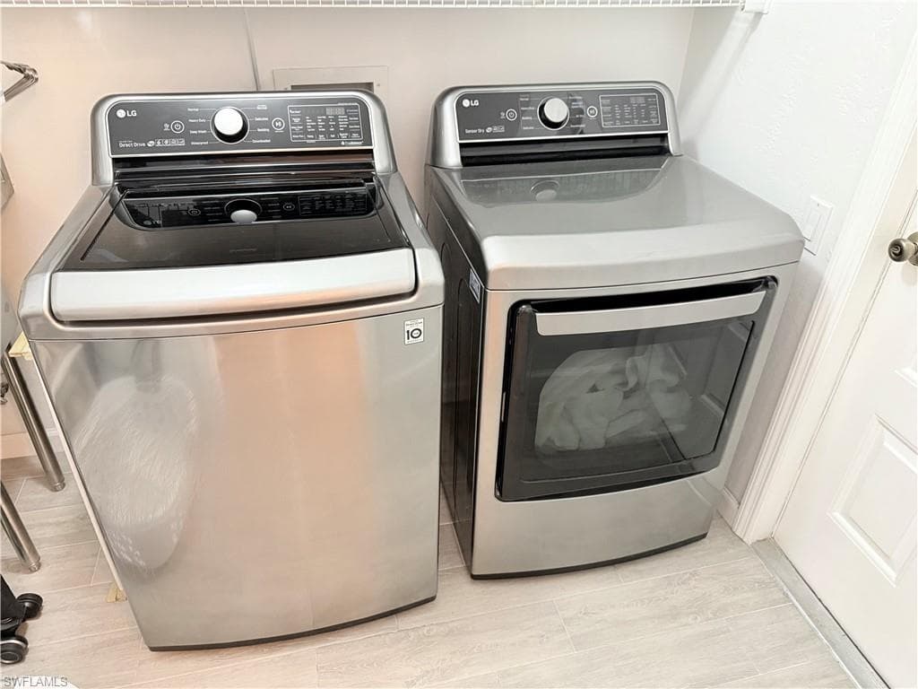 Washroom featuring separate washer and dryer and wood tiled floors
